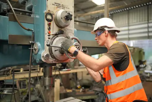 Команда мастеров за работой в светлом производственном цеху, сварка каркаса навеса